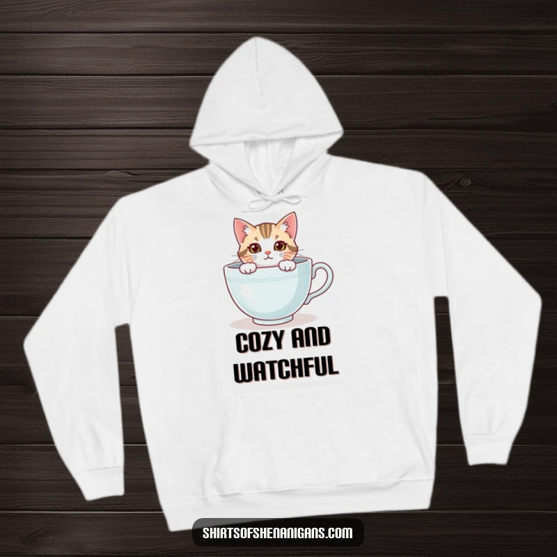Funny cat hoodie, a curious feline peeking from a large teacup, looking cozy and adorable. An awesome funny gift.