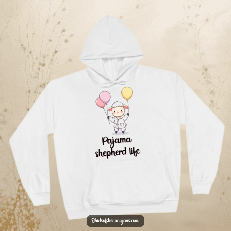 Funny hoodie featuring a sheep dressed in pajamas, hilariously attempting to herd a bunch of floating balloons with a sleepy yet focused look.