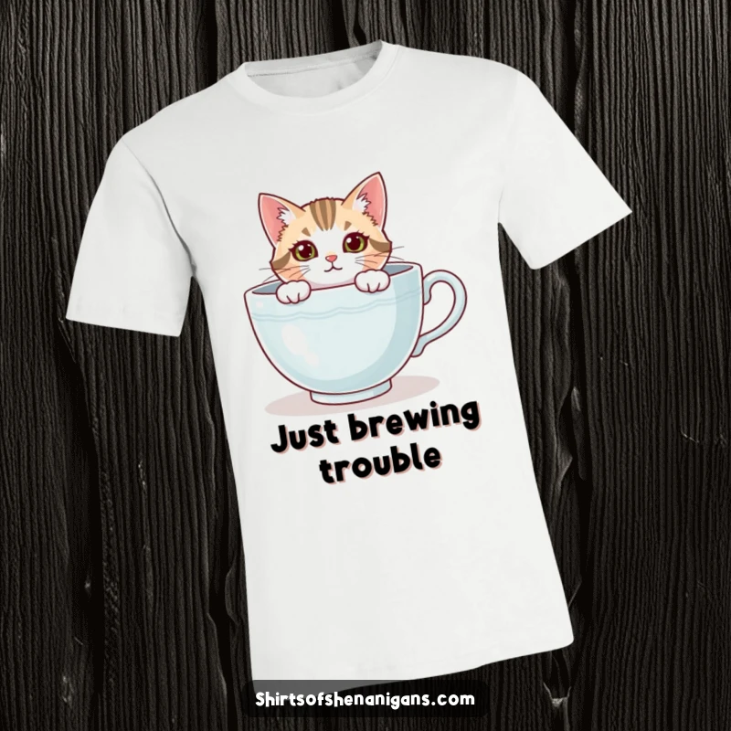 Funny cat t-shirt depicting a curious feline peeking from an oversized teacup, embodying coziness. A cool funny gift.